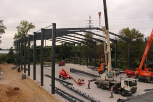 Metallständerwerk einer neuen Lagerhalle im Bau, Kran im Einsatz