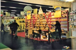 Messestand aus Holz mit vielen kleinen Fächern, Tresen, Tisch und Stühlen